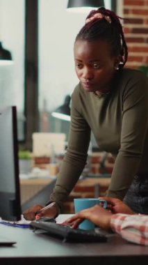 Dikey video: 3D grafik yazılımıyla çalışan profesyonel geliştirici ekibi, yeni fikirler üretiyor. Erkek ve kadın meslektaşlar iş yerinde dijital proje yaratmak için yapay zeka kullanıyorlar.