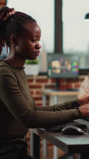 垂直ビデオ タッチスクリーンディスプレイを搭載したコンピュータ上でゲームインターフェースを設計し 3Dプロジェクト開発に取り組んでいるアフリカ系アメリカ人女性 デジタルコンテンツに人工知能を使用する女性編集者 — ストック動画