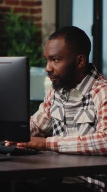 Dikey video: Afrikalı Amerikalı erkek sanatçı yazılım, dijital beceriler üzerinde CGI üretimi için stüdyo ofisinde çalışıyor. Geliştirmek için profesyonel arayüz kullanan yaratıcı ajans tasarımcısı