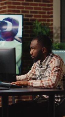 Dikey video: Afrikalı Amerikalı web geliştirici sanatsal ofiste çalışarak 3D yazılım ve dijital becerilerde CGI içeriği oluşturdu. Geliştirmek için profesyonel arayüz kullanan yaratıcı ajans tasarımcısı