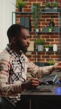Dikey video: Yaratıcı ofis çalışanı bilgisayar başında oturuyor ve birden fazla monitör ve kaba yazılım kullanarak ajans stüdyosunda dijital sanat yaratıyor. Mesleki grafik tasarımcısı