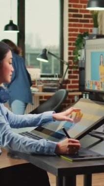 Dikey video: Tablet ve stil kalem kullanarak resimleri düzenlemek için dokunmatik ekran monitörü ile çalışan sanatçı grafik tasarımcısı. Fotoğrafçı, profesyonel içerik oluşturmak için fotoğraf düzenleme, geliştirme yazılımı.