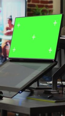 Dikey video: Dokunmatik ekranda yeşil ekran ve 3D geliştirme yazılımlarına bakan yaratıcı ajans çalışanı. İzole edilmiş kroma tuş ekranıyla çalışmak ve oyun bilgi grafikleri, telif alanı kullanarak