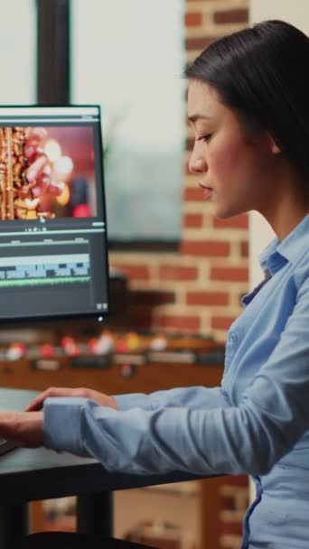 垂直视频 亚洲电影制作人在多显示器上编辑视频和音频视频 用专业的工作室蒙太奇创作电影 使用颜色分级编辑贴文的女摄影师 — 图库视频影像