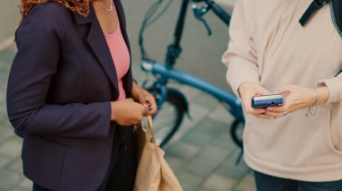 Afro-Amerikalı bir kadın yemek siparişini kredi kartıyla ödüyor. Yemek siparişi için bağlantısız bir ödeme. Sırt çantalı restoran çalışanı bayan müşteriye fast food dağıtıyor. El kamerasıyla..