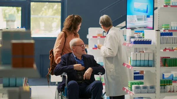 Elderly Client Wheelchair User Caretaker Talking Pharmacist Pharmacy Retail Store — Stock Photo, Image