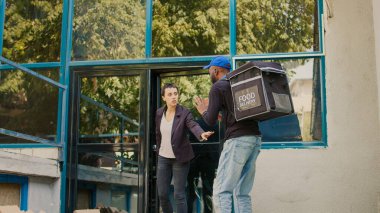 Müşterilerin önüne pizza kutuları bırakan yarım yamalak fast food şirketi. Düşen yemek paketlerini yakalayan müşteriler. Kurye özür diliyor, kötü yemek servisi. Üçayak atışı.