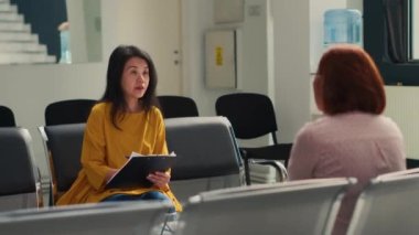 Asyalı hastalar sağlık merkezinde sağlık sigortası desteği ve tıbbi form yazmaktan bahsederek sağlık raporlarını dolduruyorlar. Tesisteki doktorla randevumuz var..