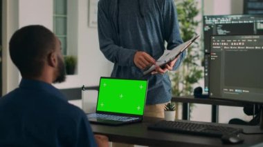 Bilgi işlem bürosunda kod geliştirme ve yeşil ekran kullanma üzerine çalışan çeşitli kodlayıcılar, programlama veritabanı. Kromakey ekran ve şablon ile izole edilmiş kopyalama uzayına bakılıyor.
