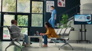 Asyalı kıdemli bir hasta uzmanla check-up randevusu yapıyor, sağlık merkezinde muayene için bekliyor. Hastalığı sigortayla tedavi etmek için doktorla görüşüyorum. Üçayak atışı.