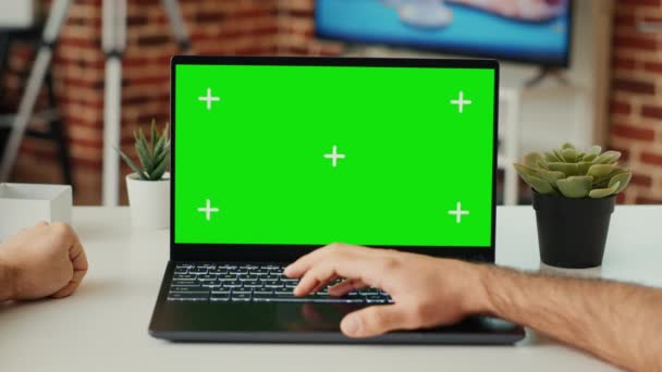 在笔记本电脑上工作的年轻成年人在办公桌前使用绿色屏幕模板 检查空白色键 并在便携式计算机上独立显示 用模拟的复制空间查看Pc 三脚架射击 靠近点 — 图库视频影像