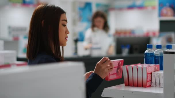 Asiatisk Kvinna Läser Kardiologi Piller Broschyr För Att Köpa Läkemedel — Stockvideo