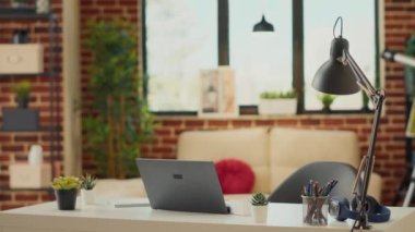 Modern dizüstü bilgisayarı olan boş bir ofis, yeni bir iş öğrenmek için rahat dairede bilgisayar kullanan yaratıcı bir şirket çalışanı. Oturma odasındaki bilgisayar muhasebe ve pazarlama işine alışkındır..