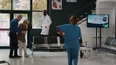 Erkek doktor kardiyak basıncı olan yaşlı bir kadına danışıyor. Hastanenin bekleme odasında mide ekşimesi var. Kalp sorunları ve kardiyovasküler hastalığı olan hasta sağlık merkezinde muayene oluyor.