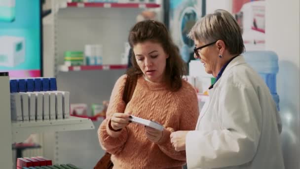 Cliente Feminino Verificando Caixa Vitaminas Falando Com Farmacêutico Sobre Tratamento — Vídeo de Stock