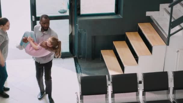 Worried Man Bringing Unconscious Girl Hospital Lobby Kid Fainting Parents — Stock Video