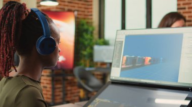 Bilgisayar ve dokunmatik ekranda oyun programlama yazılımı kullanan kadın yaratıcı mühendis, grafikler ve profesyonel arayüzle çalışıyor. CGI ve sanatsal içerik tasarımı yapan dijital sanatçı.