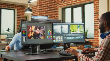 Ajans iş istasyonunda video film yapımcılığı üzerine çalışan Afrikalı Amerikalı serbest çalışan profesyonel içerik yaratıyor. Film veya film montajını düzenlemek için görüntü düzenleme yazılımı kullanan video düzenleme tasarımcısı.