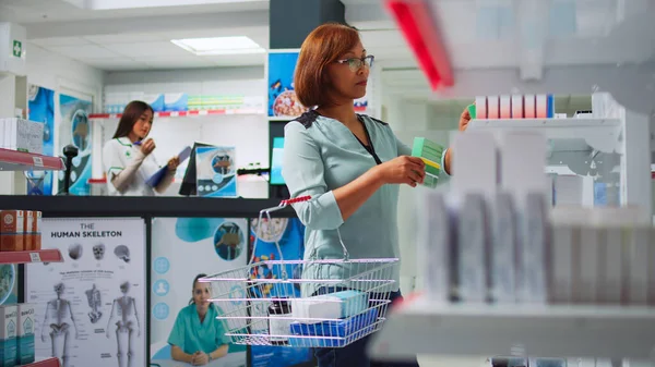 Азійка Шукає Ліки Від Таблеток Аптеці Кладучи Коробки Медикаментами Кошик — стокове фото
