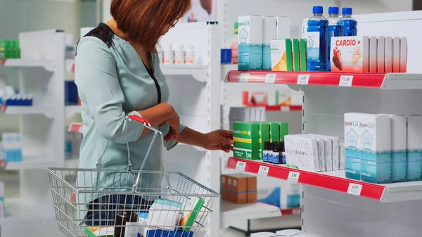 Asian Woman Taking Box Pills Pharmacy Shelves Reading Medical Leaflet — Stock Photo, Image