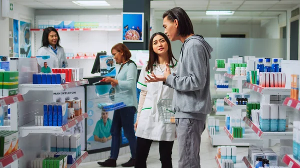 Asian Worker Explaining Pharmacy Leaflet Medical Retail Store Giving Advice — Stock Photo, Image