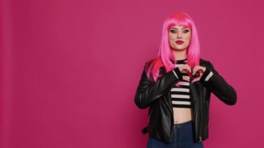 Neşeli, kendine güvenen yetişkin, elleriyle işaret eden, sevgisini ve güzel hislerini stüdyoda ifade eden. Mutlu samimi model romantik jest yapıyor, flört ediyor..