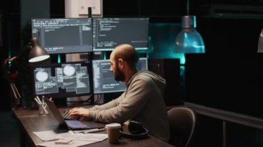 Html dili ile terminal penceresini gösteren çoklu monitörlere kaynak kod yazan yazılım mühendisi. Sistem geliştirmek için dizüstü bilgisayardaki bulut bilgisayar arayüzü programlanıyor. El kamerasıyla..