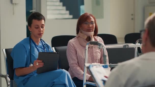Медсестра Консультирует Пациента Шейным Воротником Больничном Холле Используя Цифровые Таблетки — стоковое видео