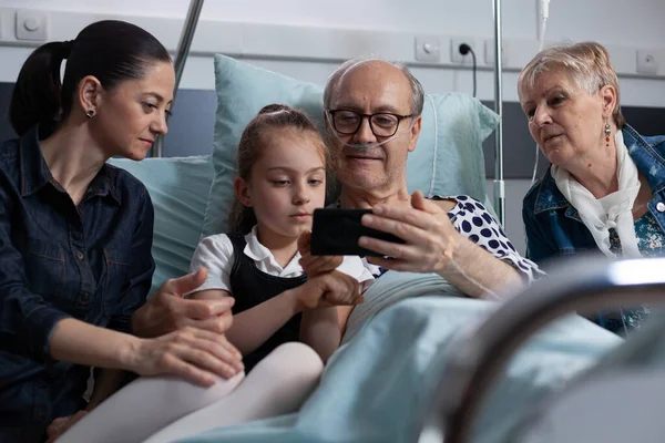 Young Woman Daughter Showing How Cell Phone Works Sick Grandfather — Stock Photo, Image