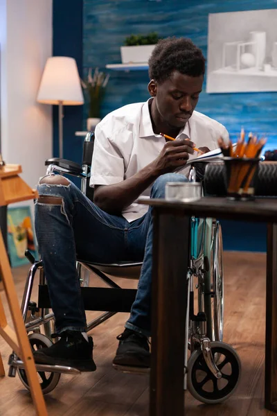 Erkek Yatak Odasındaki Masada Kağıt Kalemle Profesyonel Tekerlekli Sandalye Kullanıcısı — Stok fotoğraf
