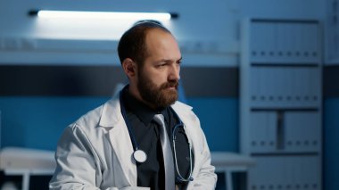 Tıbbi önlüklü pratisyen hekim hasta hastalıkları raporunu analiz ediyor, gece vardiyası sırasında bilgisayarda sağlık tedavisi yazıyor. Hastane ofisinde saatlerce çalışan hemşire. İlaç servisi.