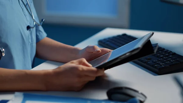 患者の専門知識を分析するタブレット型コンピュータを保有する医療補助者の閉鎖 病気診断報告書の確認は 病院の医療事務所で数時間後に行われます 医療サービス — ストック写真