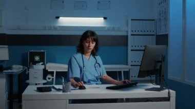 Doktor asistanı, gece geç saatlerde hastane ofisinde, muayene sırasında tıbbi rapor yazıyor. Sağlık tedavisi planlayan hasta hastalıklarını kontrol eden hemşire.