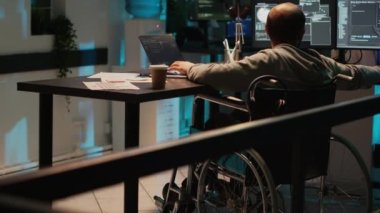 Bilgisayar ve birden fazla ekran kullanarak ağ programlama üzerinde çalışan bir sistem mühendisi. Tekerlekli sandalyede yeni kullanıcı arayüzü geliştiren kronik engelli bir erkek bilişim programcısı.