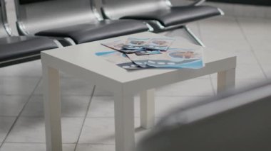Hastane lobisindeki masada profesyonel sağlık hizmetleri broşürleri boş sandalyeler ve bekleme odasındaki koltuklar. Tıbbi klinikteki bekleme alanında modern ekipman, iyileşme sigortası koridoru.