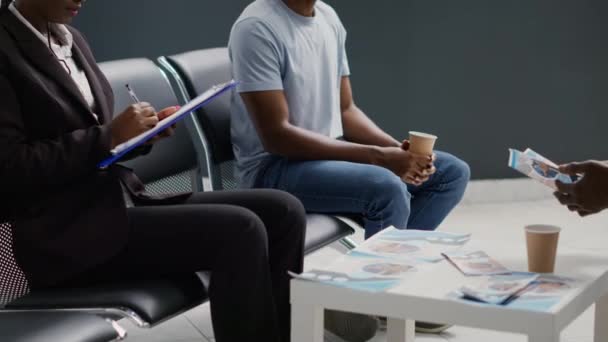アフリカ系アメリカ人は診療所の受付で待機し 診察予約を開始するのを待っている 施設内のロビーで相談又は試験を受けている者 — ストック動画