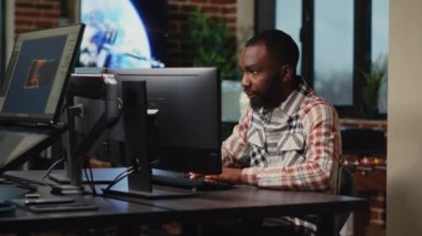 Stüdyo ofisinde çalışan Afrikalı Amerikalı erkek sanatçı yazılım ve dijital becerilerde CGI üretimi için çalışıyor. Bilgi grafiklerini geliştirmek için profesyonel arayüz kullanan yaratıcı ajans tasarımcısı.