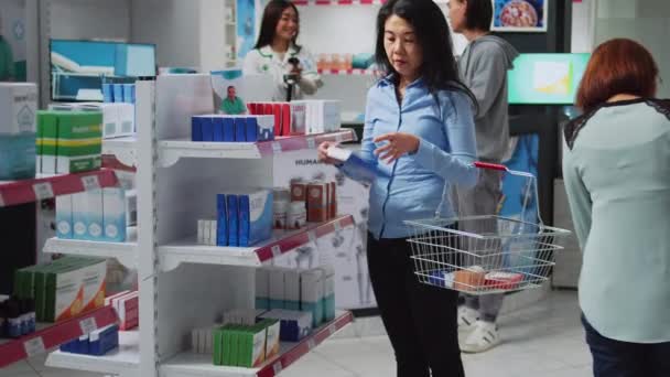Asiatische Kundin Liest Rezept Auf Tablettenschachteln Betrachtet Medikamente Und Nahrungsergänzungsmittel — Stockvideo