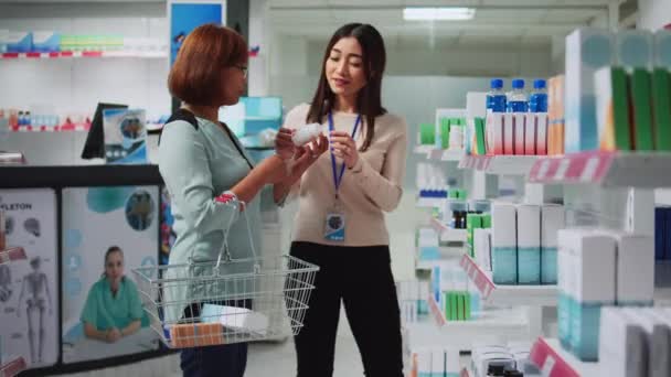 Gyógyszertár Asszisztens Elmagyarázza Vitaminokat Női Ügyfélnek Beszél Gyógyszertárban Fiatal Segít — Stock videók