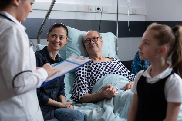 환자를 분만시키는 의사는 요양원 대기실에 가족들에게 결과를 보여준다 병원에서 일하는 — 스톡 사진