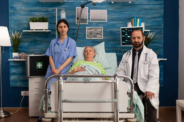 老人ホームのベッドに寝そべっている女性の肖像画 高齢者介護 保健支援サービスを専門とする医師看護師 — ストック写真