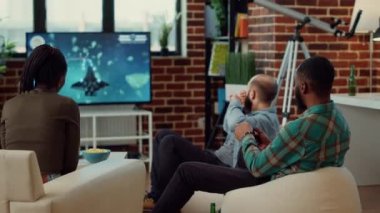 Mutlu insanlar video oyunları oynar ve yarışmayı kazanır, TV konsolunda online yarışmayı kazanır. Ev partisinde başarıyı çekerken eğleniyor ve neşeli hissediyorum..