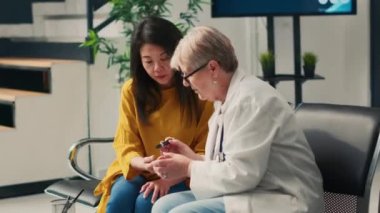 Bekleme alanındaki lobide glukometre kullanan insülin seviyesindeki çeşitli kadınlar kan örneğinden glikozu ölçmek için diyabet muayenesi yapıyorlar. Sağlık ve hasta check-up ziyaretinde.