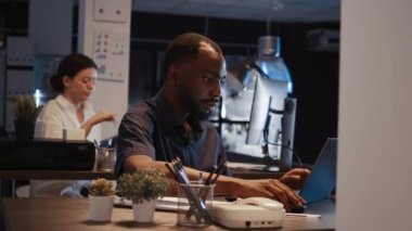 Erkek yönetici satış paylaşımı ve yatırımla belgeleri analiz ediyor, dizüstü bilgisayar üzerinde rapor planlamak için araştırma projesi yapıyor. Sunum yapmak ve yönetici e- postası göndermek için kullanılıyor. El kamerasıyla..