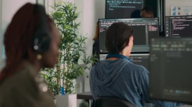Veritabanı programcısı terminal penceresine ajans ofisindeki birden fazla monitörü kullanarak kod yazıyor. Sistem yazılım geliştiricisi veritabanı bilgisini yazıyor, büyük veri betiği hesaplanıyor.