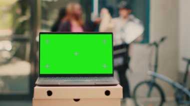 Laptop reklamları dışarıda yeşil ekran şablonu, yemek teslimatı ön kapıda. Bilgisayar ekranında boş model ve telif alanı arkaplanı ile izole edilmiş krom anahtar görüntüsü çalıştırılıyor.