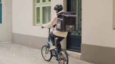 Afro-Amerikan müşterilere paket halinde restoran yemeği getiren yemek kuryesi. Ön kapıda kağıt torba siparişi veriyor. Kadın taşıyıcı hazır yemek, hızlı yemek servisi..