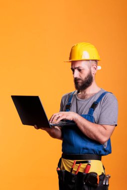Genç tamirci, internet sitesini gezmek için dizüstü bilgisayar kullanıyor, ilham arıyor. İnşaat alanı uzmanı taşınabilir bilgisayarı kablosuz ağ ile tutuyor, mühendislik işinde inşaatçı.