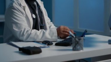Hasta hastalıkları uzmanlığını analiz ederken hastane ofisinde gece vardiyasında çalışan yorgun pratisyen hekim. Sağlık tedavisi planlayan doktor