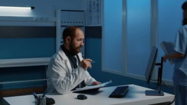 Doktor doktor, gece geç saatlere kadar hastane ofisinde çalışırken bilgisayardaki veri uzmanlığına bakarak tıbbi raporlarla karşılaştırıyor. İlaç hizmeti ve konsept